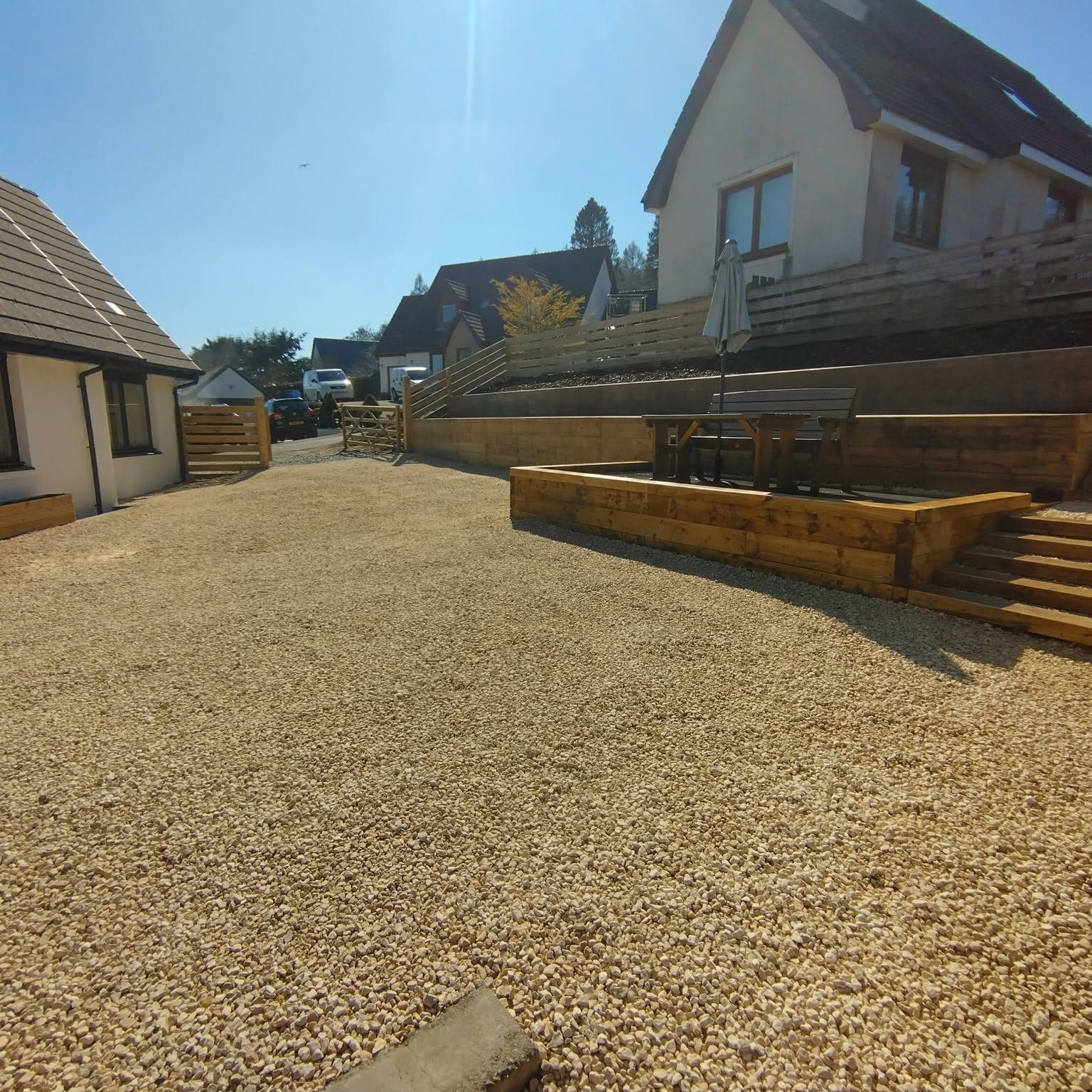 Pebbles in driveway, with patio and various houses